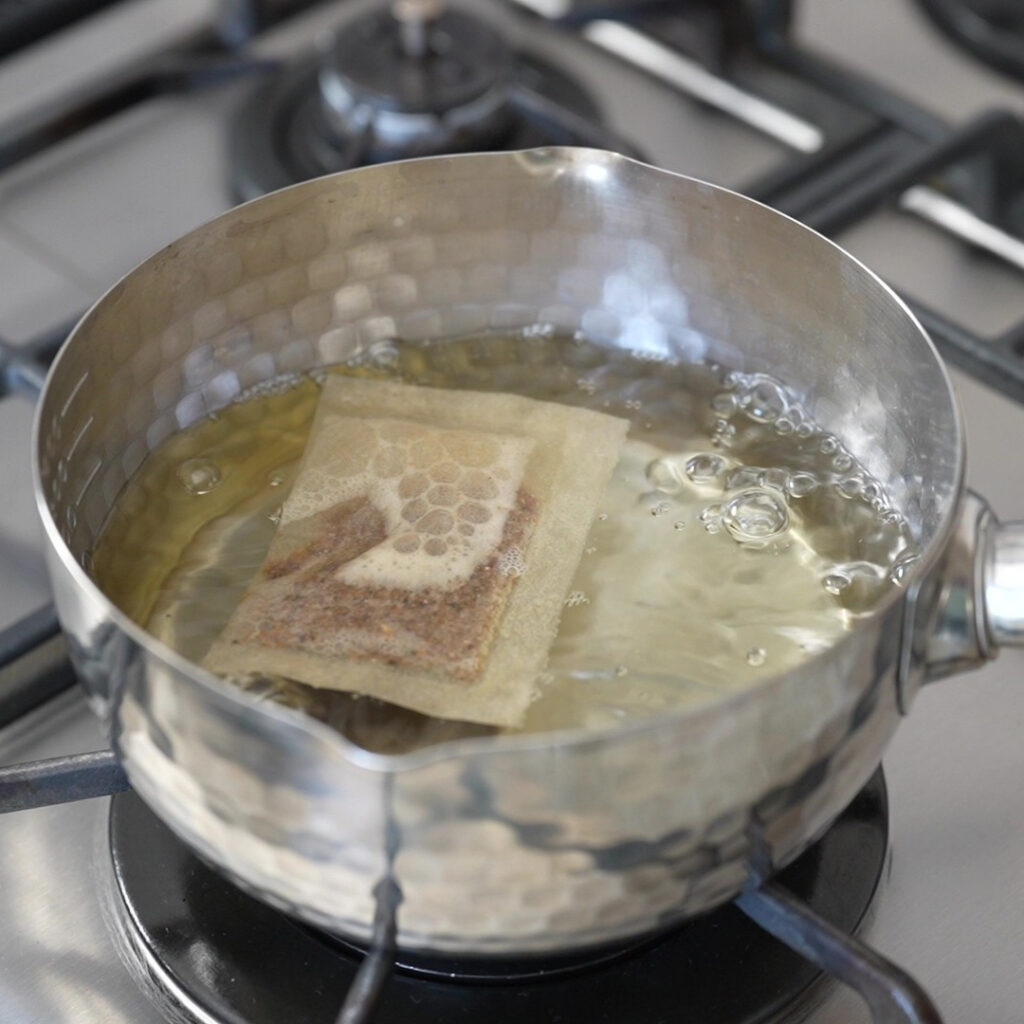 Dashi packet simmering in a pot of water.