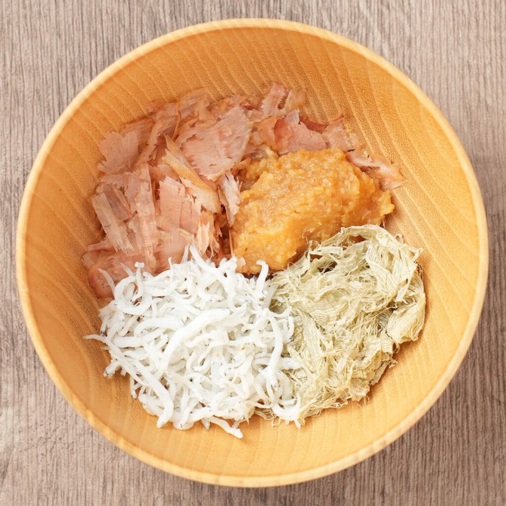Kachuyu ingredients in a wooden bowl with bonito flakes, miso, dried shirasu, and tororo kombu.