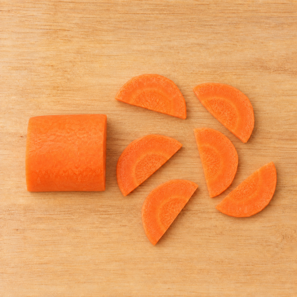Carrot cut into half-moon slices on a wooden cutting board