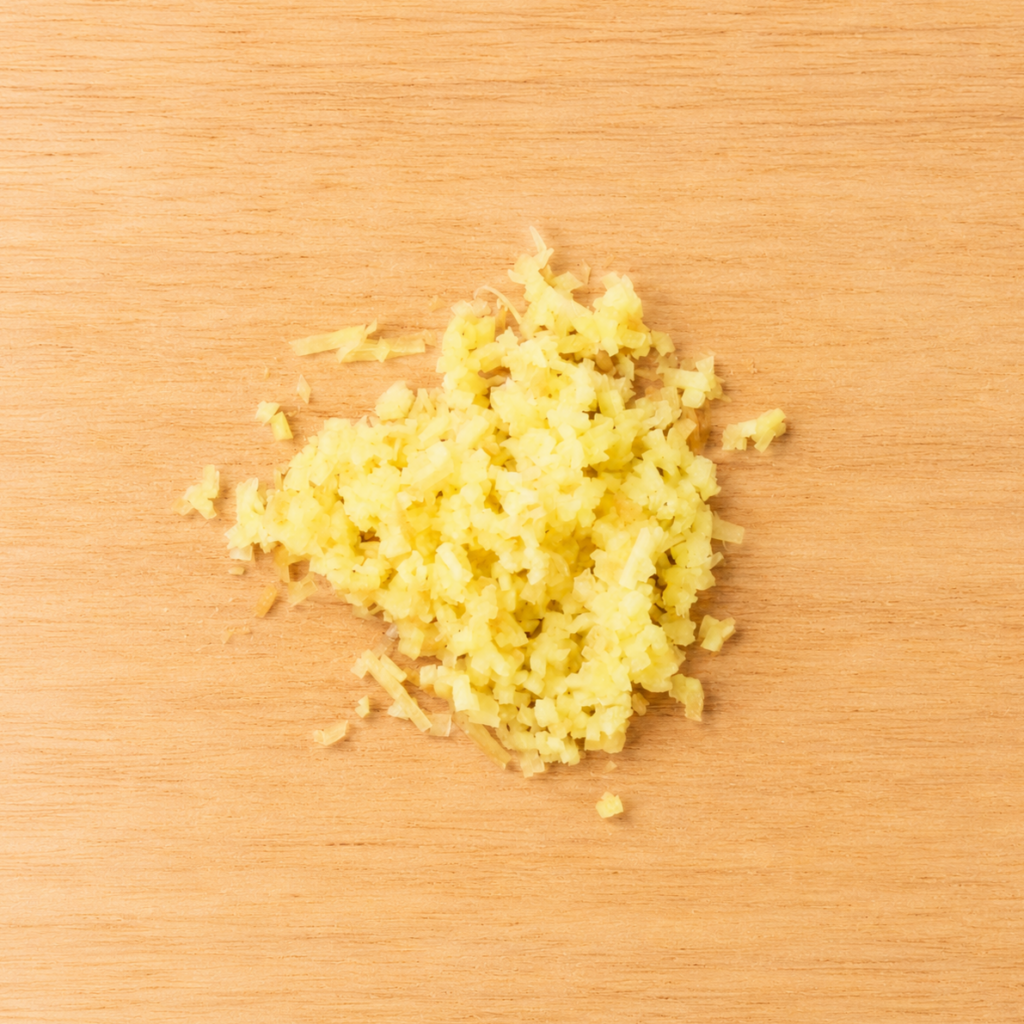 Finely minced ginger on a wooden cutting board