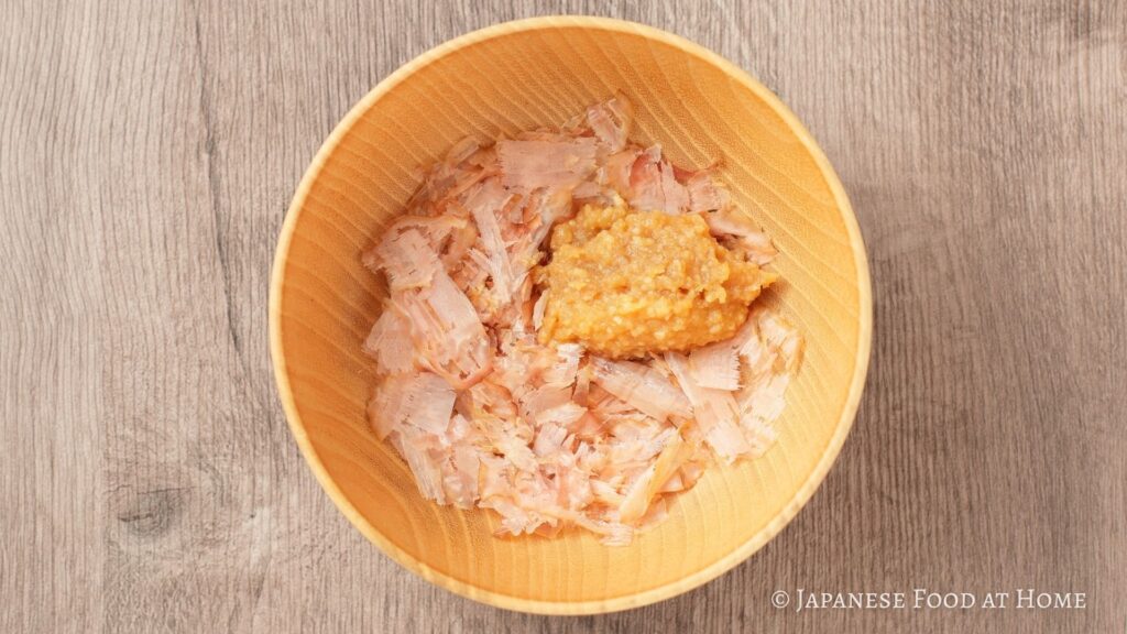 Miso and bonito flakes placed in a wooden bowl before adding hot water to make kachuyu.