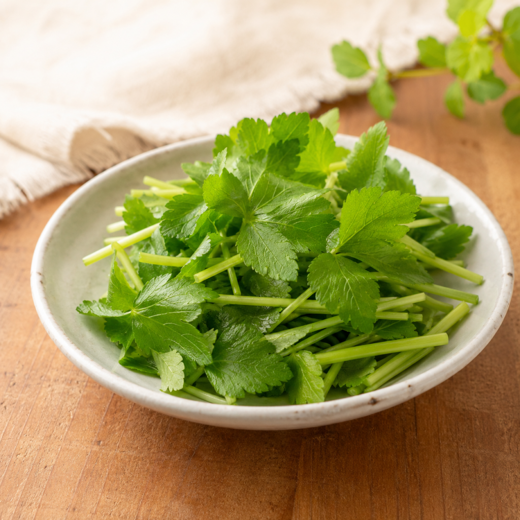 Fresh mitsuba cut into short pieces and served in a small ceramic dish.