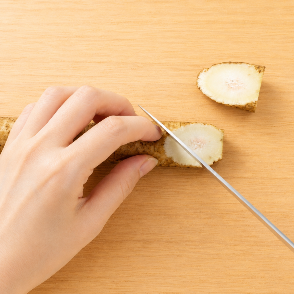 Burdock root being cut diagonally for the rangiri rolling-cut technique