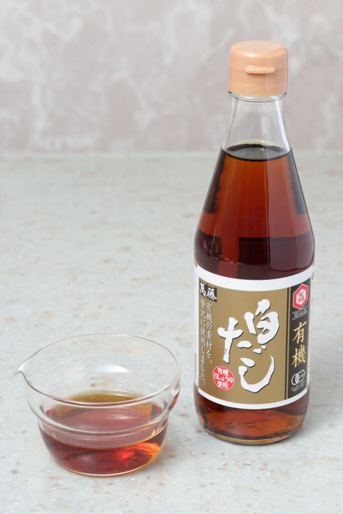 Bottle of shiro dashi with shiro dashi in a small glass bowl.