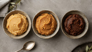 Three small bowls of Japanese miso showing white miso, light-colored miso, and red miso from above.